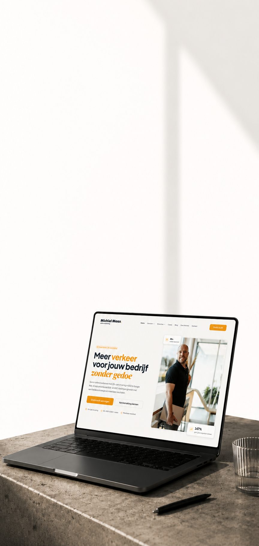 Klikstroom website weergegeven op een laptop, op een betonnen rand met warm ochtendlicht.